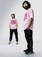 Load image into Gallery viewer, Stay Weird Soft Pink Unisex Oversized T-Shirt Front View Of Male and Female