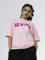 Load image into Gallery viewer, Be Kind Soft Pink Unisex Oversized T Shirt front design view of female 
