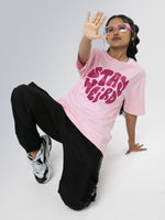 Load image into Gallery viewer, Stay Weird Soft Pink Unisex Oversized T-Shirt Front View Of Female
